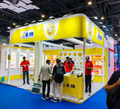K-10 abrasive products exhibition stall featuring yellow and white branding with illuminated product displays