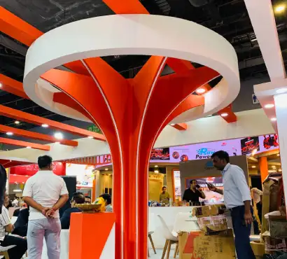 Techno Industrial Products exhibition stall featuring a custom orange and white structure with branded product displays
